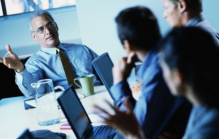 Businesspeople Using Laptops During Meeting